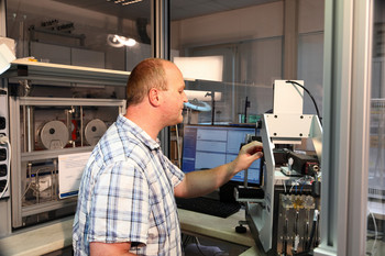 Wissenschaftler bei der Arbeit an einem Kontaktwinkelmessgerät zur Untersuchung der Benetzbarkeit von Oberflächen.