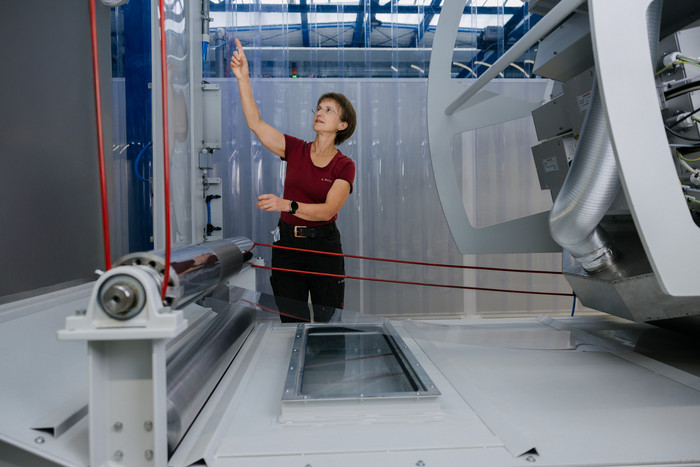 Technischer Mitarbeiter an der Rolle-zu-Rolle Anlage zur Fertigung von transparenten flexiblen Verkapselungsfolien für Dünnschichtphotovoltaik. Foto: Erik Kazak Technische Mitarbeiterin arbeitet an der Rolle-zu-Rolle Anlage zur Fertigung von transparenten flexiblen Verkapselungsfolien für Dünnschichtphotovoltaik.