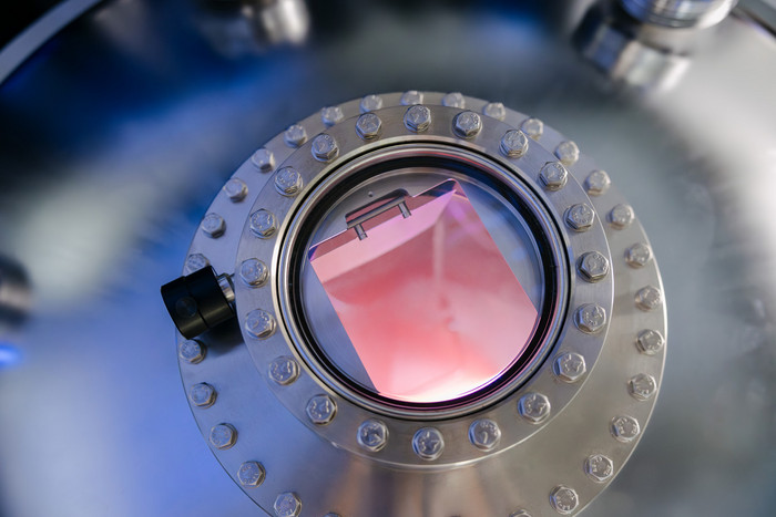 Blick in eine Vakuumkammer beim Hochleistungsimpuls-Magnetronsputtern einer Titankathode in einer Argon-Atmosphäre bei Niederdruck. Foto: Erik Kazak Blick in eine Vakuumkammer beim Hochleistungsimpuls-Magnetronsputtern einer Titankathode in einer Argon-Atmosphäre bei Niederdruck.