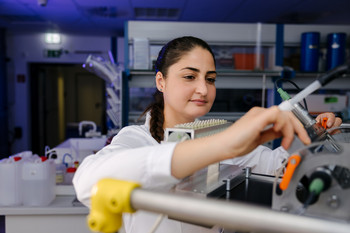 Eine Technikerin arbeitet am photokatalytischen Membranreaktor, der für Abbauversuche mit Methylenblau eingesetzt wird.
