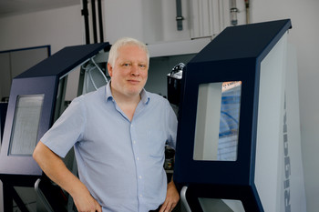Ein wissenschaftlicher Mitarbeiter steht am Multifunktions-Röntgenstrahldiffraktometer für die Analyse von Schichteigenschaften.