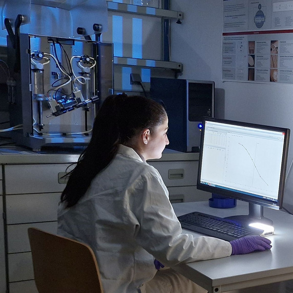 Technikerin sitz an einem Computer und führt Zetapotentialmessungen zur Bestimmung der Oberflächenladung von Membranen durch.