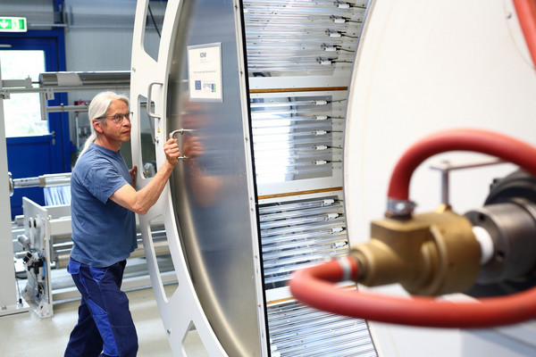 Techniker bereitet die Rolle-zu-Rolle-Anlage zur Fertigung von transparenten flexiblen Verkapselungsfolien für Dünnschichtphotovoltaik vor.