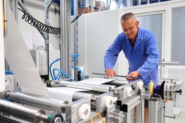 Techniker bereitet die Pilotanlage zur kontinuierlichen Elektronenstrahl-Behandlung von Membranen vor.